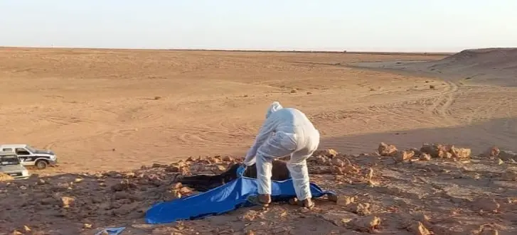 Security personnel examine the site where the body of an unidentified African migrant was discovered near the Ghadames border area in northwestern Libya, following a report from local authorities.