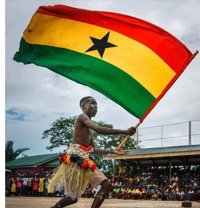 A Ghanaian flag bearer raises the national flag in a public display of identity and unity in Accra.