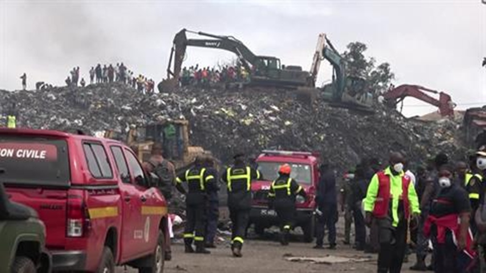 Emergency workers and heavy machinery conduct search-and-rescue operations at a collapsed landfill in Conakry, Guinea, after heavy rainfall triggered the disaster, killing dozens and damaging nearby homes.