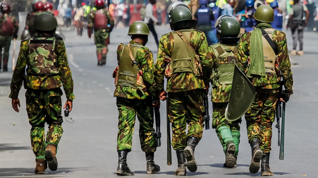 Kenyan police officers patrol on foot during an active security operation in urban streets.