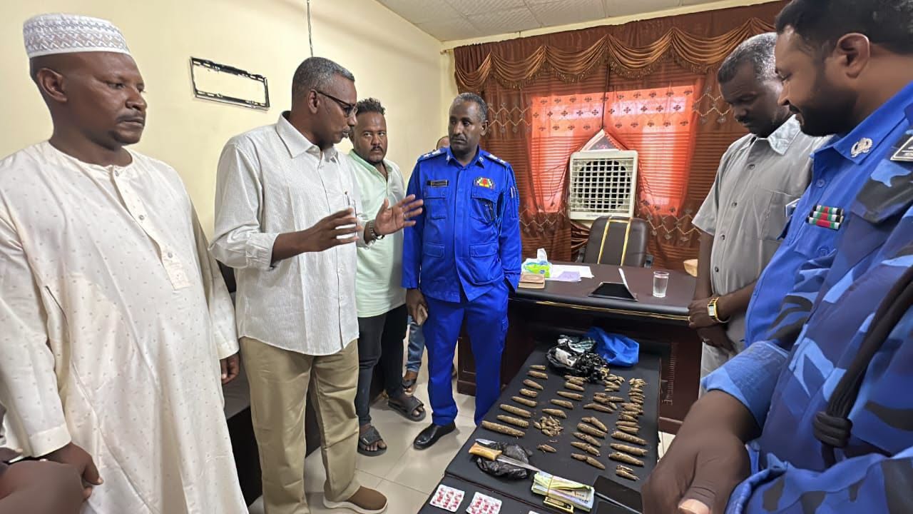 Sudanese local officials and police officers inspect suspected narcotics and cash displayed following a drug seizure in Wadi Halfa, Northern State.