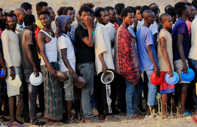 Ethiopian men who fled war in Tigray region, queue for wet food ration at the Um-Rakoba camp, on the Sudan-Ethiopia border in Al-Qadarif state, Sudan November 19, 2020. (Reuters)
