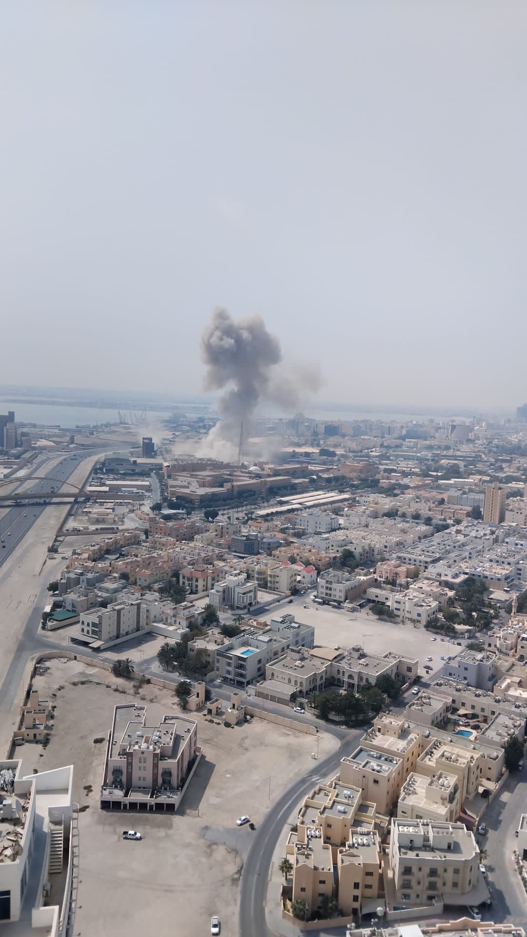 Smoke rises near the U.S. Navy Fifth Fleet services center in Bahrain after reported missile strikes on Saturday, as regional tensions escalate sharply amid Iran's retaliatory actions.