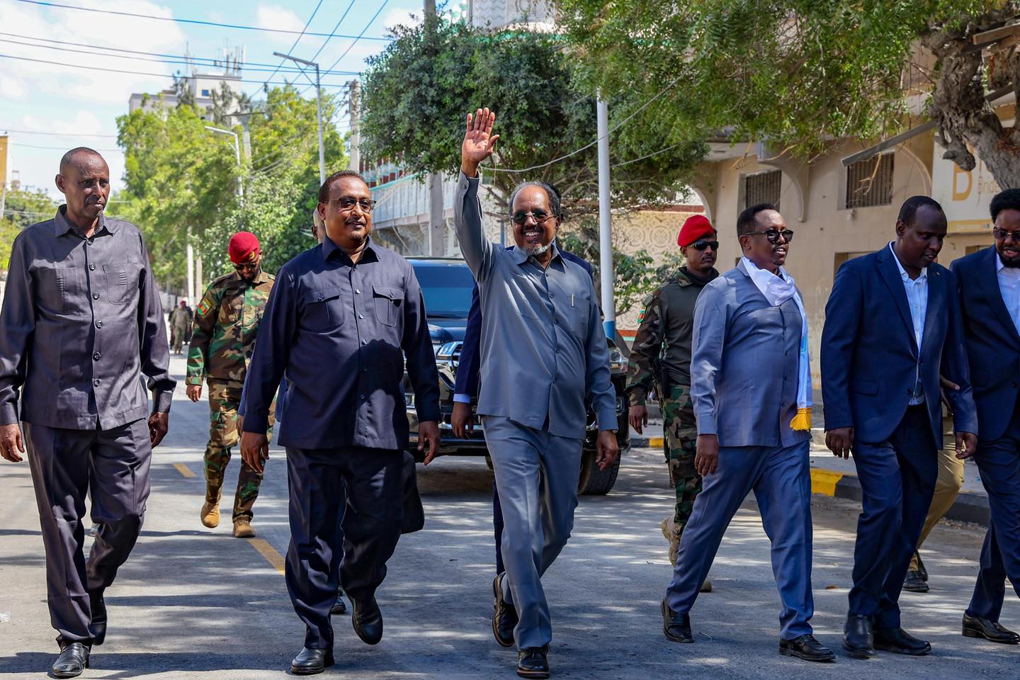 Somali President Hassan Sheikh Mohamud greets a crowd on a Mogadishu sidewalk by the newly opened Bakara Market road.