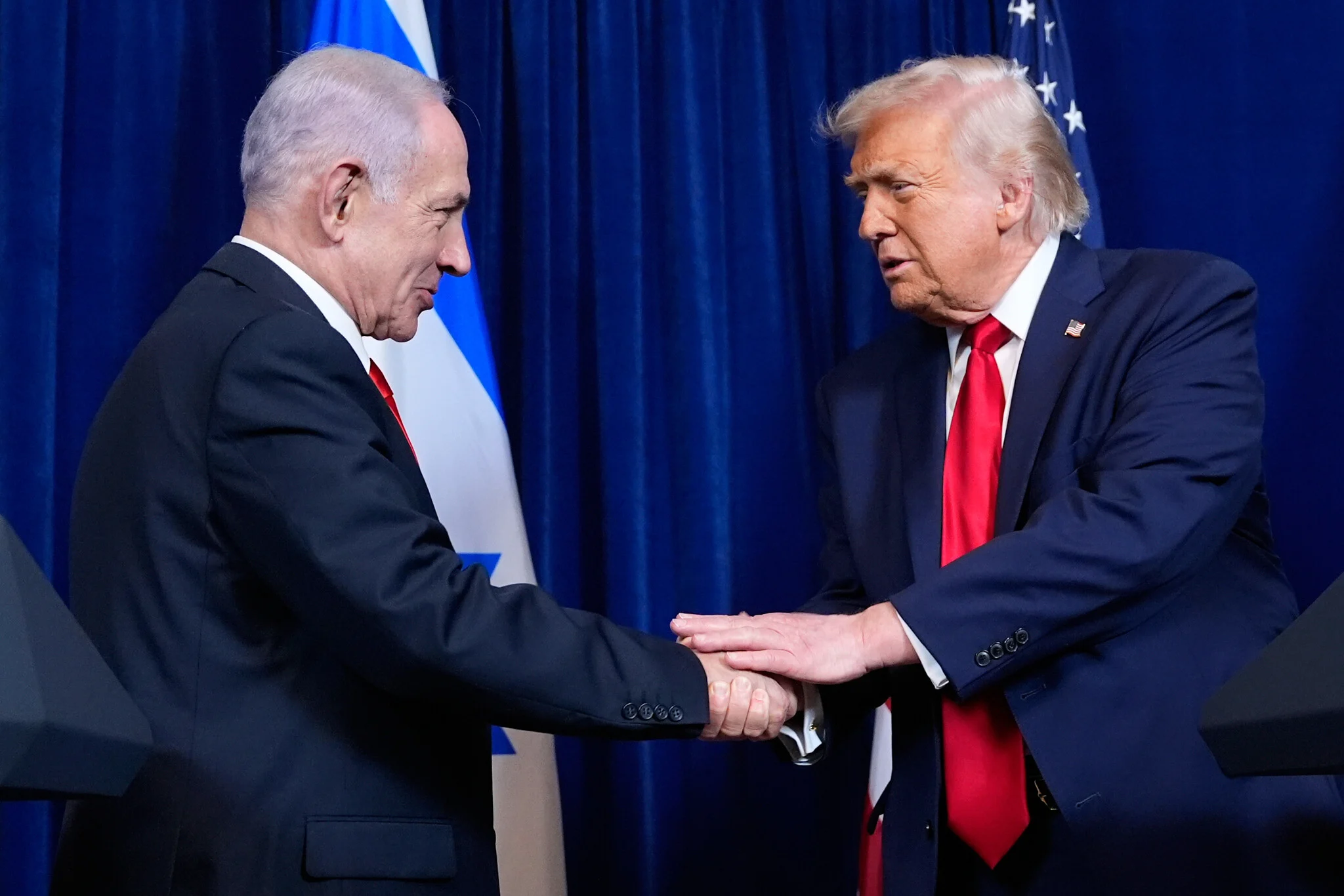 US President Donald Trump, right, shakes hands with Prime Minister Benjamin Netanyahu during a news conference at Mar-a-Lago, on December 29, 2025, in Palm Beach, Florida. (AP Photo/Alex Brandon)