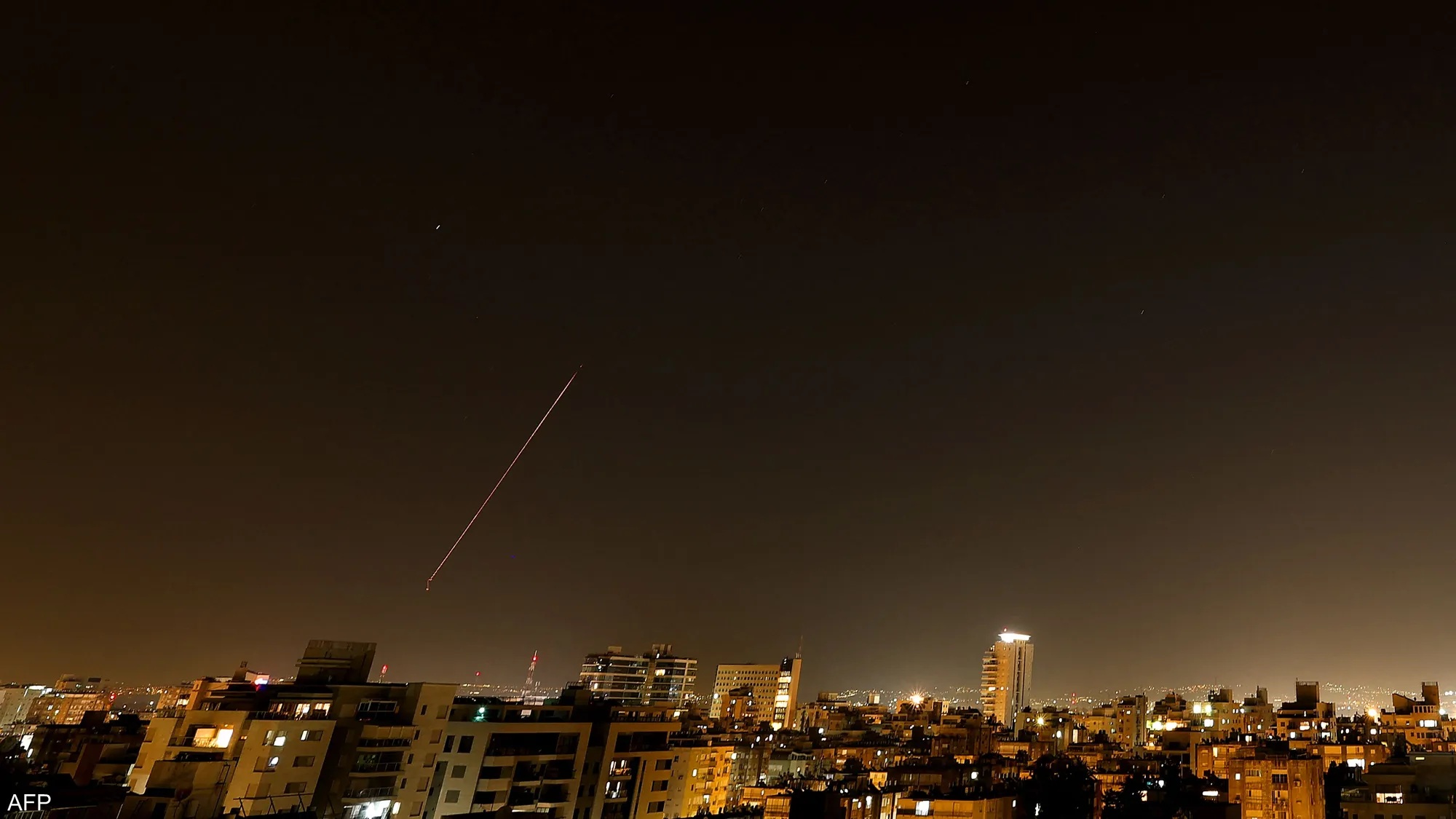 Iranian missiles visibly streak across Israel's night sky. Israeli defense forces reportedly intercepted several of the projectiles over central cities.