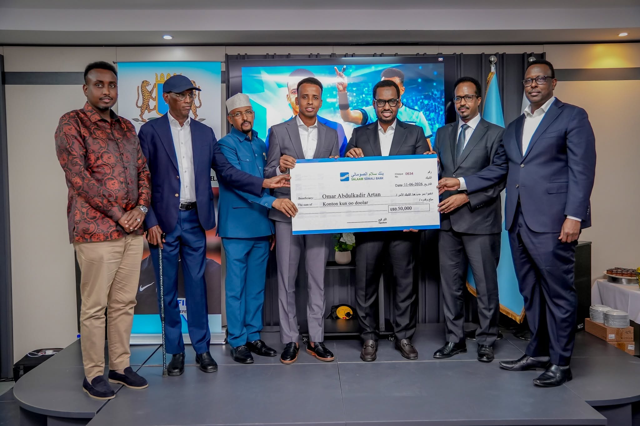 Somali businessman Liban Ahmed Hassan, a candidate for leader of Galmudug State, presents a $50,000 cash recognition award to referee Omar Artan during a public ceremony in Mogadishu, in the presence of ministers and officials from the Prime Minister's Office.
