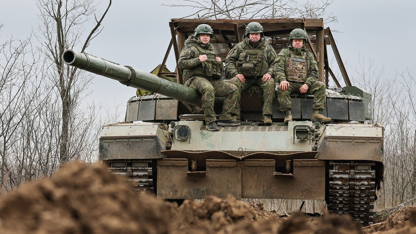 Three Russian soldiers ride atop a tank during operations in Luhansk, eastern Ukraine, as military activity continues in the region.