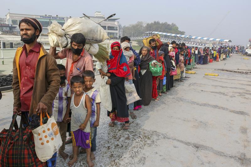 FILE - In this Feb. 15, 2021, file photo, Rohingya refugees headed to the Bhasan Char island prepare to board navy vessels from the south eastern port city of Chattogram, Bangladesh. Authorities in Bangladesh on Tuesday, Aug. 10, 2021, started vaccinating Rohingya refugees against coronavirus for the first time across massive camps where more than 1 million refugees from neighboring Myanmar have been sheltered, officials and the U.N. refugee agency said. (AP Photo, File)