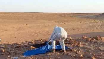 Security personnel examine the site where the body of an unidentified African migrant was discovered near the Ghadames border area in northwestern Libya, following a report from local authorities.