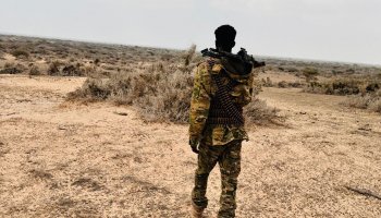 Somali National Army soldier conducts a patrol while monitoring the surrounding area for security.