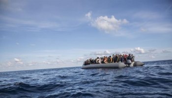 Inflatable boat carrying migrants in the open sea during a dangerous journey across rough waters.