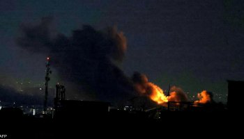 Smoke rises in massive plumes from an airstrike site in Tehran.