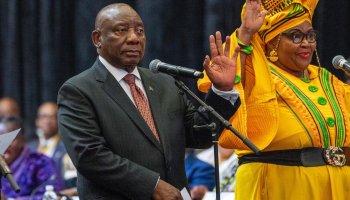 South African President Cyril Ramaphosa raises his hand as he is sworn is as a member of Parliament ahead of an expected vote by lawmakers to decide if he is reelected as leader of the country in Cape Town, South Africa, Friday. At right is Pemmy Majodina, a lawmaker with his African National Congress party.  Jerome Delay / AP