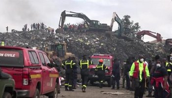 Emergency workers and heavy machinery conduct search-and-rescue operations at a collapsed landfill in Conakry, Guinea, after heavy rainfall triggered the disaster, killing dozens and damaging nearby homes.