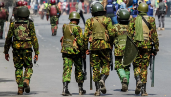 Kenyan police officers patrol on foot during an active security operation in urban streets.