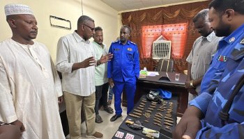 Sudanese local officials and police officers inspect suspected narcotics and cash displayed following a drug seizure in Wadi Halfa, Northern State.