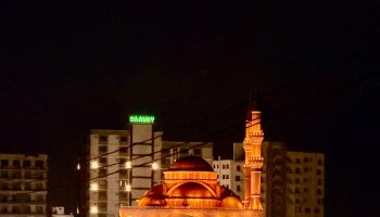 A view of Mogadishu, Somalia's capital, featuring the Ali Jimale Mosque and towering skyscrapers in the background.