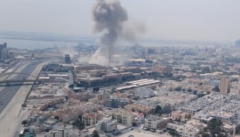 Smoke rises near the U.S. Navy Fifth Fleet services center in Bahrain after reported missile strikes on Saturday, as regional tensions escalate sharply amid Iran's retaliatory actions.