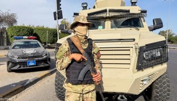 A masked soldier stands guard at an undisclosed location in Libya.