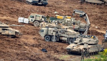 Israeli tanks advance near the Lebanon border amid rising tensions.