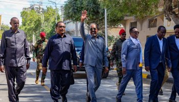 Somali President Hassan Sheikh Mohamud greets a crowd on a Mogadishu sidewalk by the newly opened Bakara Market road.