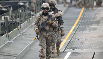 U.S. forces walk through a military facility as operations continue during the ongoing 