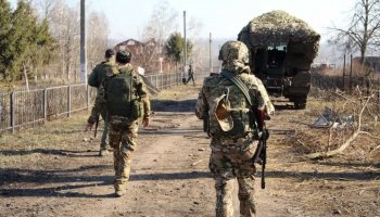 Russian service members walk along a street in a part of the Kursk region which was recently retaken by Russia's armed forces / Russian Defence Ministry via Reuters.