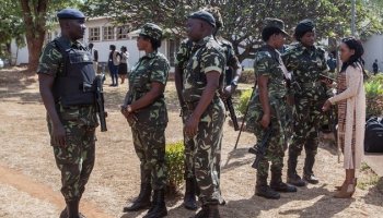 Malawi Police Service paramilitary officers in camouflage uniforms patrol during a public order operation.