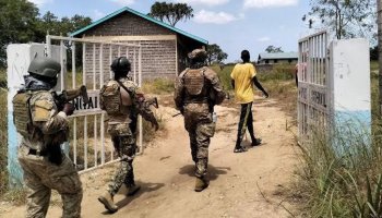 Kenyan police officers during a coordinated security operation targeting illicit alcohol and narcotics, inspecting and securing evidence during a raid.