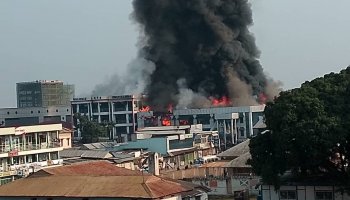 Flames and thick smoke rise from the Le Parisien and Ndayizamba shopping galleries as emergency crews respond to the fire in central Bujumbura, Burundi, on August 21, 2026.